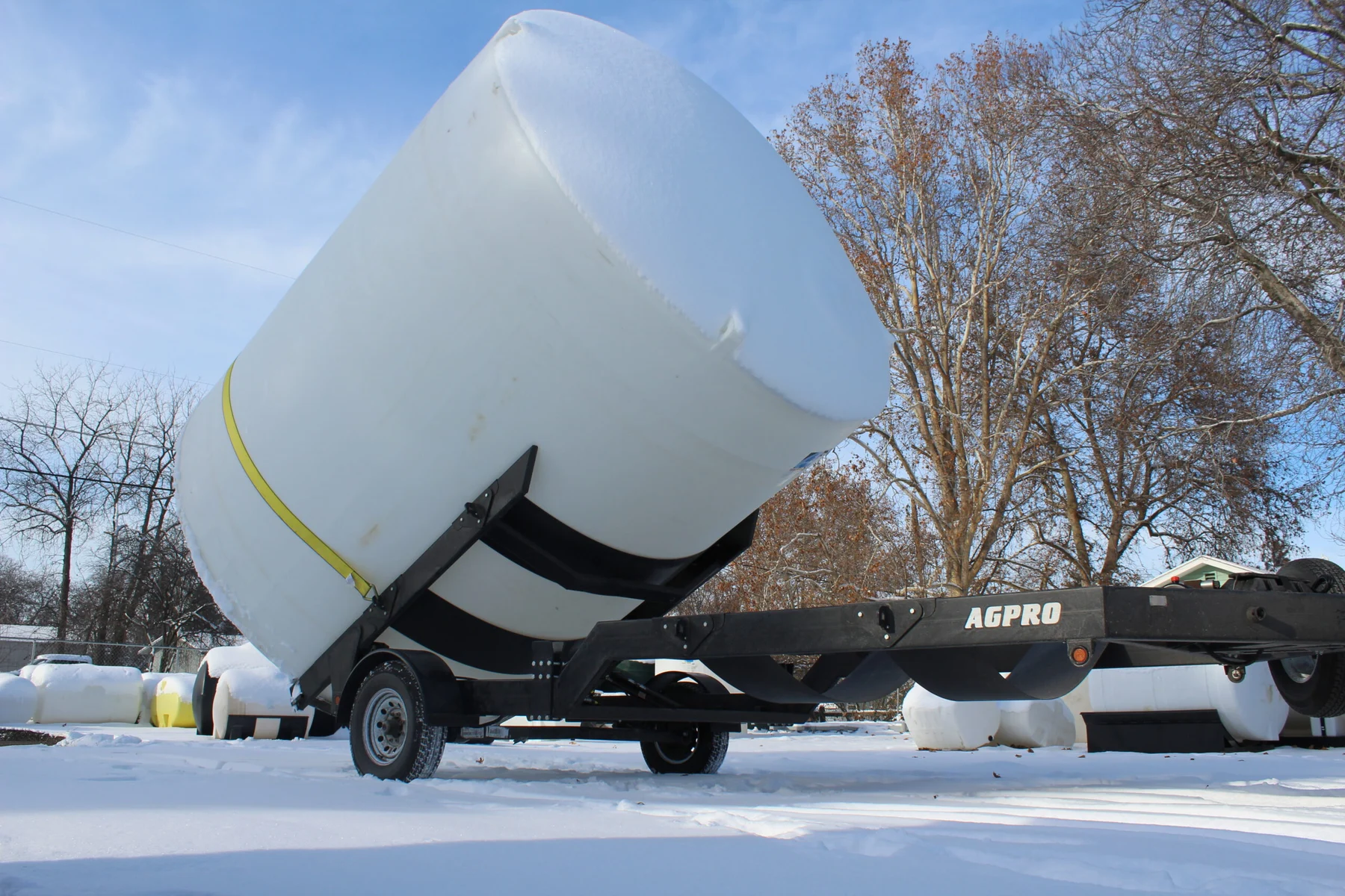 AGPRO hydraulic tilt trailer raising a strapped storage tank